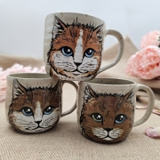 Kubek ceramiczny beżowo-piaskowy ceramiczny z uchem ręcznie toczony i malowany z kotkiem kubek kot ręcznie malowany
