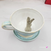 Filiżanka ZAJĄC ceramiczna ze spodkiem z ZAJĄCEM szarakiem w środku ręcznie toczona i malowana w kolorze białym i błękitnym oraz szary zając kubek zając z zającem szarakiem filiżanka na Wielkanoc