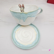Filiżanka ZAJĄC ceramiczna ze spodkiem z ZAJĄCEM szarakiem w środku ręcznie toczona i malowana w kolorze białym i błękitnym oraz szary zając kubek zając z zającem szarakiem filiżanka na Wielkanoc