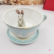 Filiżanka ZAJĄC ceramiczna ze spodkiem z ZAJĄCEM szarakiem w środku ręcznie toczona i malowana w kolorze białym i błękitnym oraz szary zając kubek zając z zającem szarakiem filiżanka na Wielkanoc