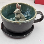 Filiżanka ZAJĄC ceramiczna ze spodkiem z ZAJĄCEM szarakiem w środku ręcznie toczona i malowana w kolorze ciemno - brązowym i zielonym kubek zając z zającem szarakiem Wielkanoc