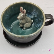 Filiżanka ZAJĄC ceramiczna ze spodkiem z ZAJĄCEM szarakiem w środku ręcznie toczona i malowana w kolorze ciemno - brązowym i zielonym kubek zając z zającem szarakiem Wielkanoc