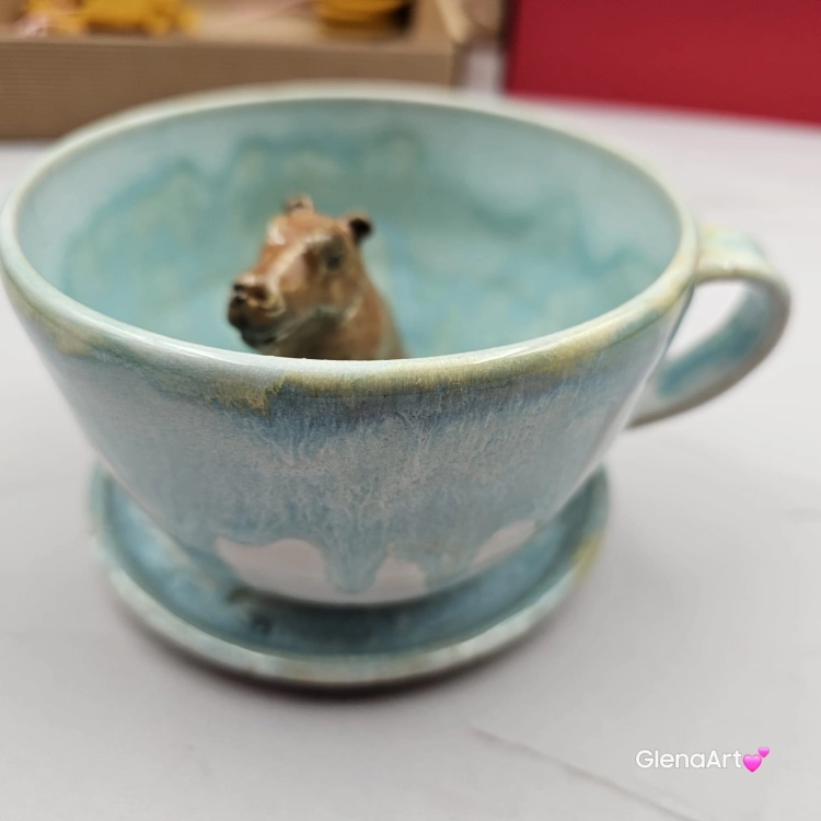 Filiżanka KAPIBARA ceramiczna ze spodkiem i kapibarą w środku ręcznie toczona i malowana w kolorze błękitnym i białym elegancka filiżanka z zabawnym zwierzątkiem kapibara kubek