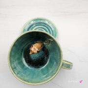 Filiżanka SURYKATKA ze spodkiem ceramiczna z uroczą SURKĄ w środku ręcznie toczona i malowana odcienie zieleni i niebieskiego kubek na prezent dla miłośnika natury piękna filiżanka w odcieniach zieleni turkusowe jeziorko surykatka