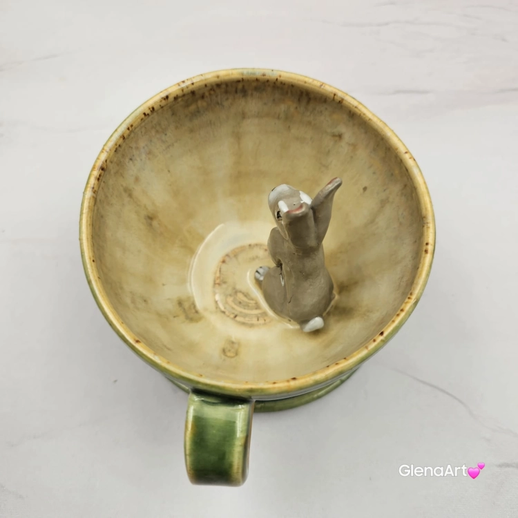 Filiżanka ZAJĄC ceramiczna ze spodkiem z ZAJĄCEM szarakiem w środku ręcznie toczona i malowana w kolorach zielonych niebieskich brązach i beżach oraz szary zając kubek zając z zającem szarakiem filiżanka na Wielkanoc i nie tylko