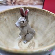 Filiżanka ZAJĄC ceramiczna ze spodkiem z ZAJĄCEM szarakiem w środku ręcznie toczona i malowana w kolorach zielonych niebieskich brązach i beżach oraz szary zając kubek zając z zającem szarakiem filiżanka na Wielkanoc i nie tylko