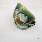 Filiżanka ZAJĄC ceramiczna ze spodkiem z ZAJĄCEM szarakiem w środku ręcznie toczona i malowana w kolorach zielonych niebieskich brązach i beżach oraz szary zając kubek zając z zającem szarakiem filiżanka na Wielkanoc i nie tylko