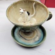 Filiżanka KOT biały NIEIDEALNA ceramiczna ze spodkiem z KOTEM w środku ręcznie toczona i malowana w kolorach zielonych niebieskich brązach i beżach oraz biały kot kubek