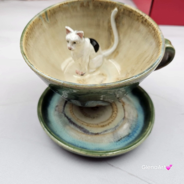 Filiżanka KOT biały NIEIDEALNA ceramiczna ze spodkiem z KOTEM w środku ręcznie toczona i malowana w kolorach zielonych niebieskich brązach i beżach oraz biały kot kubek